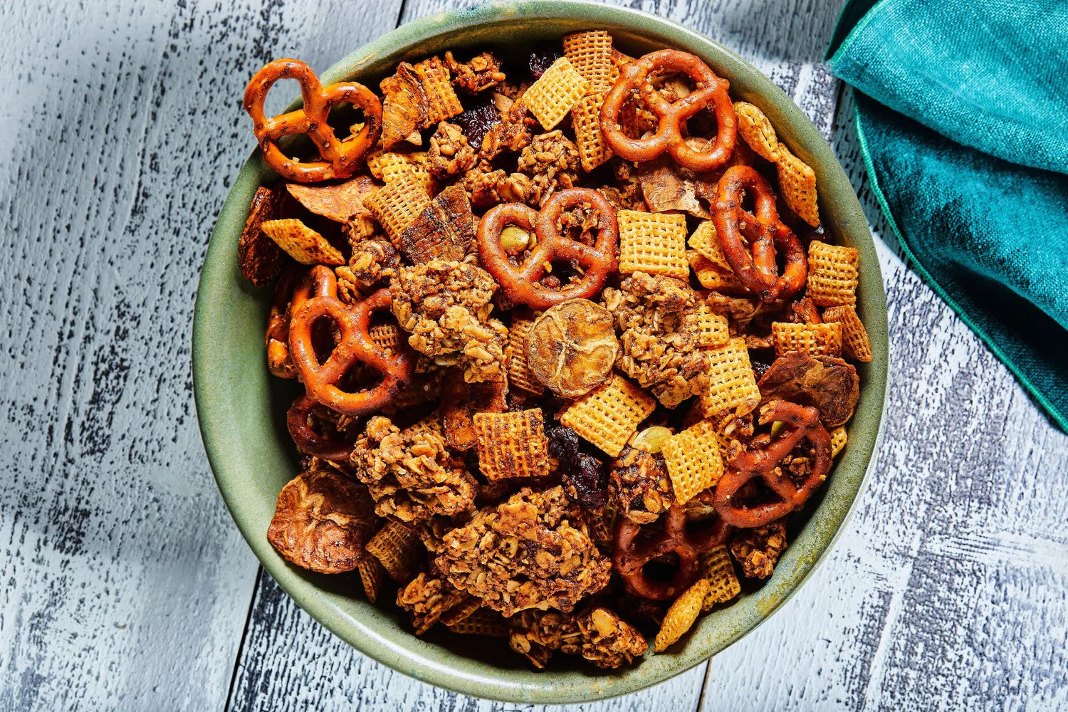 Sweet and savory granola trail mix with pretzels, cereal squares, dried fruit, and Michele's Granola