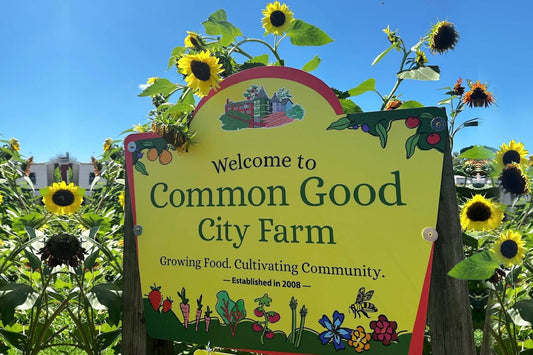 Sign with sunflowers and statement "Welcome to Common Good City Farm" 
