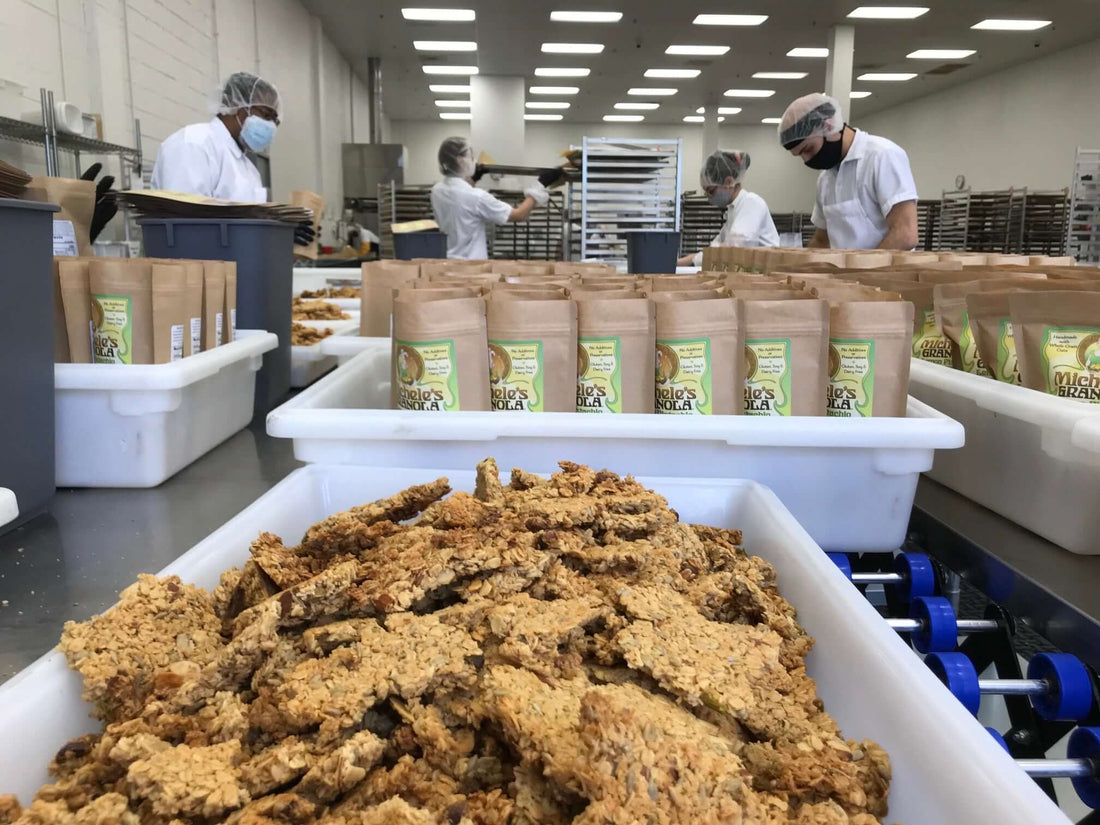 Press Release: Production process at Michele's Granola facility with packaged products and staff working.