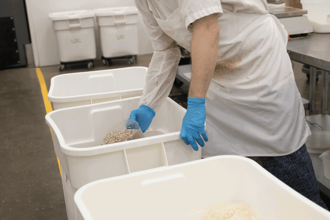 Michele's Granola bakery team measuring ingredients into bins, protein-rich foods for meal preparation.