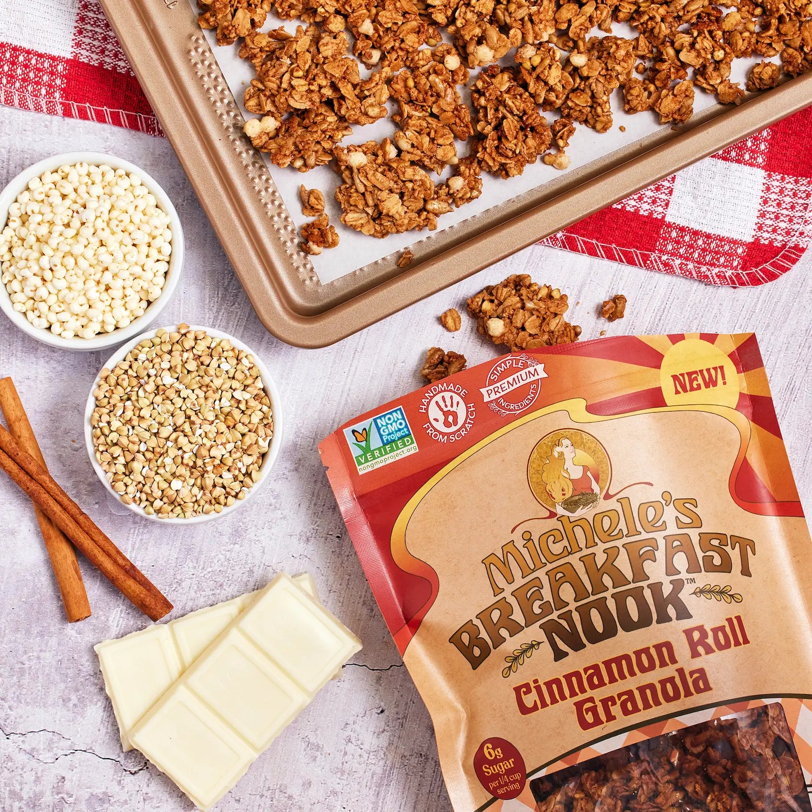 Michele's Breakfast Nook Cinnamon Roll Granola with ingredients and packaging on a table.