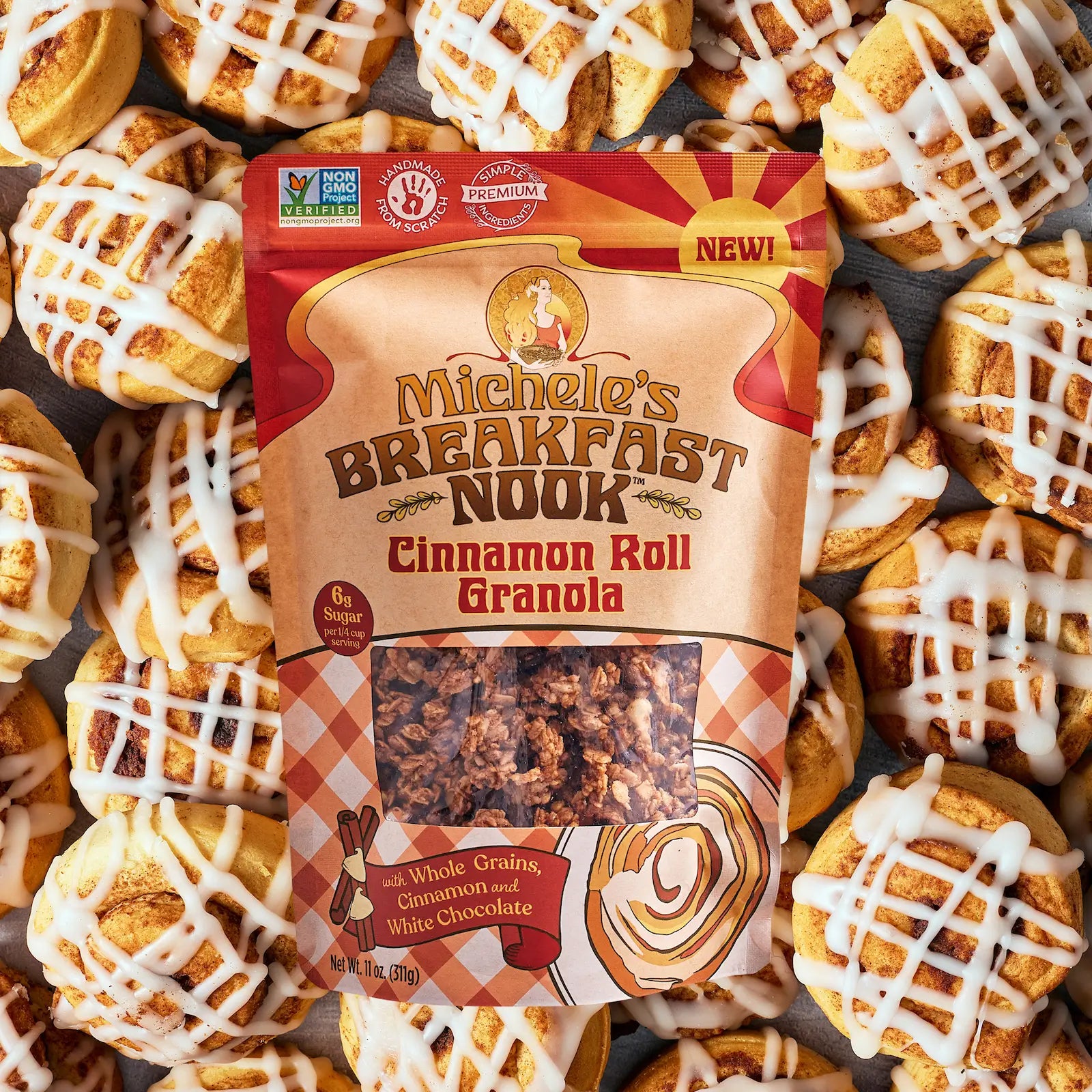 Michele's Breakfast Nook Cinnamon Roll Granola package surrounded by cinnamon rolls